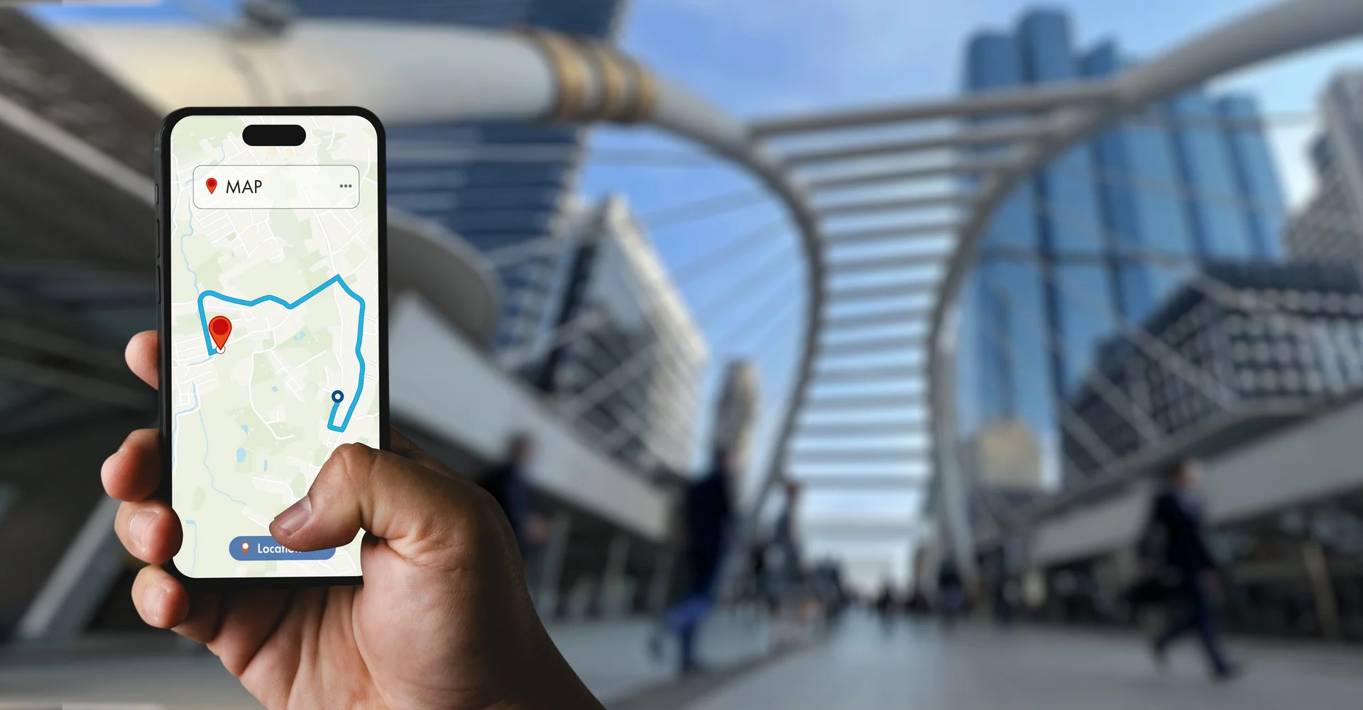 Hand holding a smartphone showing a GPS map route in an urban street